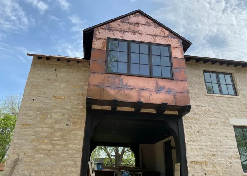 Copper metal panel facade on a stone building for Skylight Installation in Wilton