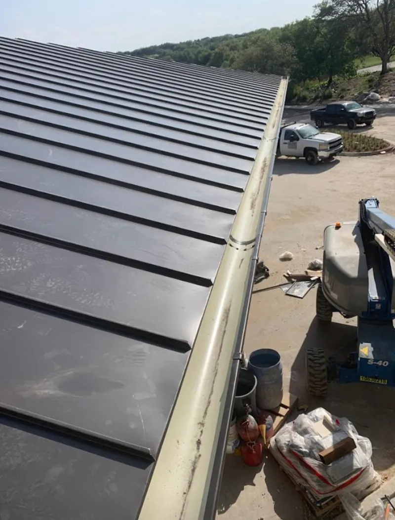 Standing seam panel and gutter detail on a metal roofing jobsite in Wilton